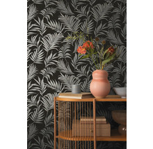 Dekorativní tapeta s motivem palmových listů v kombinaci s regálovými prvky a dekoracemi.