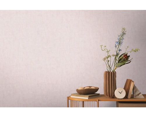 Dekorativní zátiší s vázou, květinami a knihami před vzorovanou tapetou