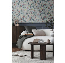 Obývací pokoj s květinovou tapetou, pohovkou, stolem a dekoracemi pro útulnou atmosféru.