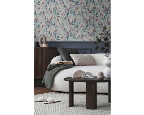 Obývací pokoj s květinovou tapetou, pohovkou, stolem a dekoracemi pro útulnou atmosféru.