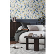 Obývací pokoj s květinovou tapetou, pohovkou, konferenčním stolkem a dekorativními doplňky pro útulnou atmosféru.