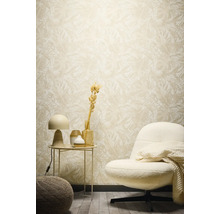 Dekorativní obývací pokoj s květinovou tapetou, křeslem a odkládacím stolkem.