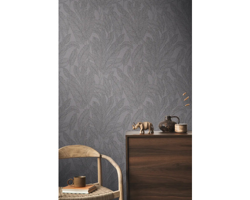 Pohled na místnost s vzorovanou tapetou a dekorativními prvky na dřevěné skříni.