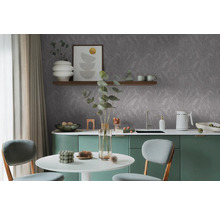 Moderní kuchyně s šedou tapetou s listy, jídelním stolem a zelenými skříňkami.