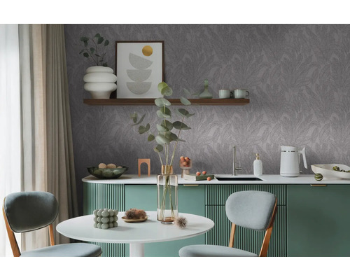 Moderní kuchyně s šedou tapetou s listy, jídelním stolem a zelenými skříňkami.