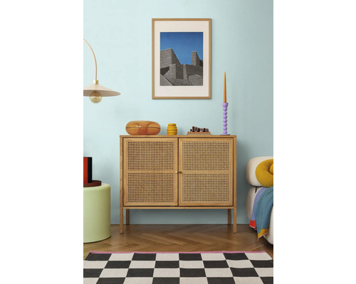 Interiér obývacího pokoje s komodou, dekorací a zarámovaným obrazem