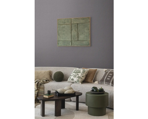 Obývací pokoj s pohovkou, polštáři, stolem a nástěnnou dekorací