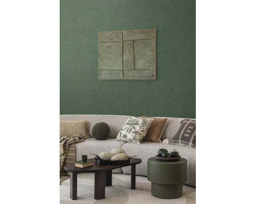 Obývací pokoj s pohovkou, polštáři, konferenčním stolkem a nástěnnou dekorací pro útulnou atmosféru