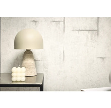 Dekorativní stolní lampa s travertinovou základnou vedle bublinkové svíčky na stole