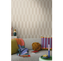 Světlý obývací pokoj s vzorovanou tapetou, šedou pohovkou a dekorativními prvky, jako jsou polštáře a deky