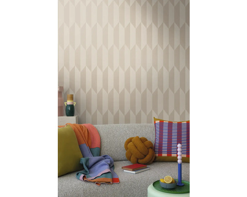 Světlý obývací pokoj s vzorovanou tapetou, šedou pohovkou a dekorativními prvky, jako jsou polštáře a deky