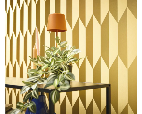 Dekorativní zlatá tapeta s geometrickým vzorem šipek v interiéru.