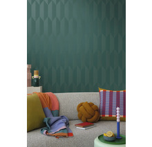 Obývací pokoj s šedou pohovkou, polštáři, přikrývkami a vzorovanou tapetou pro stylový interiér.