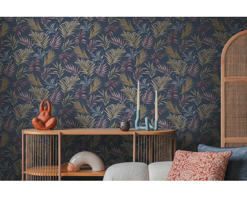 Scéna s tmavou tapetou se vzorem listů, stůl a dekorativní předměty