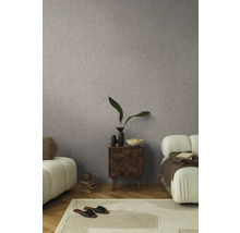 Obývací pokoj s vzorovanou tapetou, kobercem, pohovkou a odkládacím stolkem.