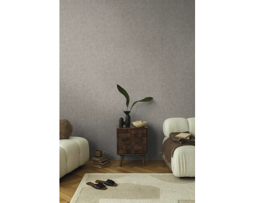 Obývací pokoj s vzorovanou tapetou, kobercem, pohovkou a odkládacím stolkem.