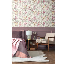 Ložnice s květinovou tapetou, postelí, křeslem a nočním stolkem