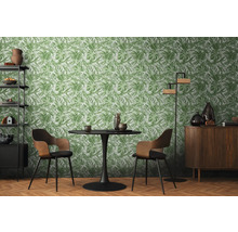 Obývací pokoj s jídelním stolem, židlemi, regálem, skříní a tapetou s rostlinným vzorem.