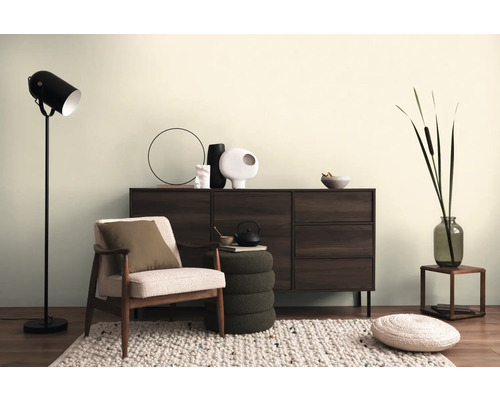 Obývací pokoj s křeslem, komodou, stojací lampou a dekorativními doplňky pro útulnou atmosféru