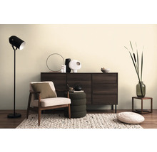 Obývací pokoj se skříňkou, křeslem, stojací lampou a dekorativními prvky na koberci