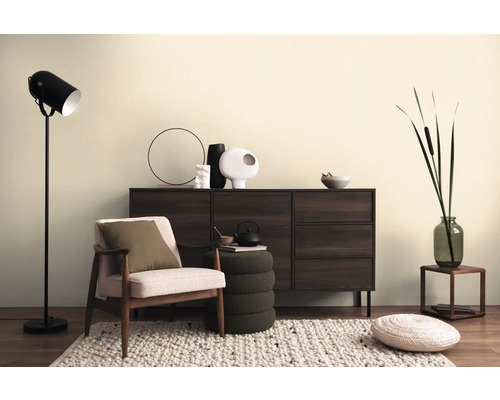 Obývací pokoj se skříňkou, křeslem, stojací lampou a dekorativními prvky na koberci