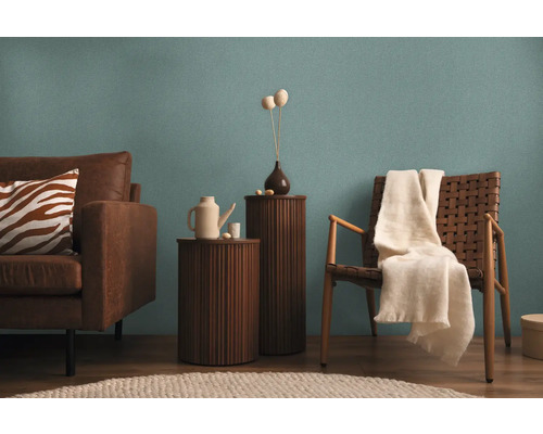 Obývací pokoj s pohovkou, židlemi a odkládacími stolky před stěnou