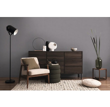 Obývací pokoj s křeslem, stojací lampou a komodou pro útulnou atmosféru