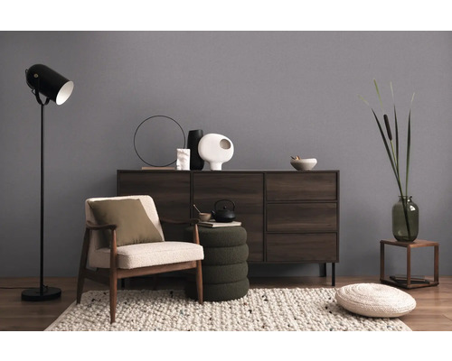 Obývací pokoj s křeslem, stojací lampou a komodou pro útulnou atmosféru