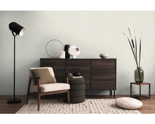 Obývací pokoj s křeslem, komodou, stojací lampou a dekoracemi pro útulnou atmosféru.