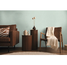 Obývací pokoj s pohovkou, židlí a odkládacími stolky ve světlém prostředí