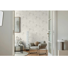 Obývací pokoj s vzorovanou tapetou, křeslem a dekorací