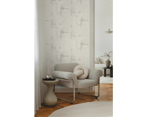 Obývací pokoj se strukturovanými tapetami a šedým křeslem