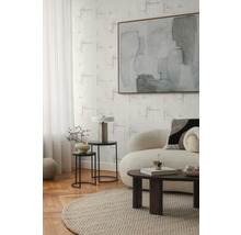 Obývací pokoj s pohovkou, konferenčním stolkem, odkládacími stolky, lampou a abstraktním obrazem