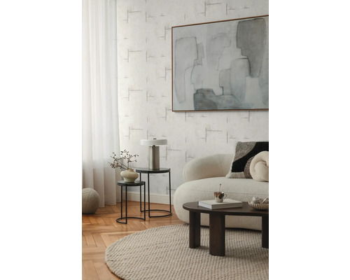 Obývací pokoj s pohovkou, konferenčním stolkem, odkládacími stolky, lampou a abstraktním obrazem