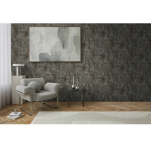 Obývací pokoj s křeslem, stolem a dekorací před strukturovanou stěnou