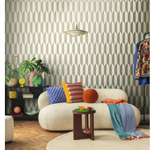 Obývací pokoj s geometrickou tapetou, pohovkou, odkládacím stolkem a dekorativními prvky pro stylové prostředí.