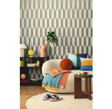 Obývací pokoj s vzorovanou tapetou, pohovkou, odkládacím stolkem a dekoracemi pro útulnou atmosféru.