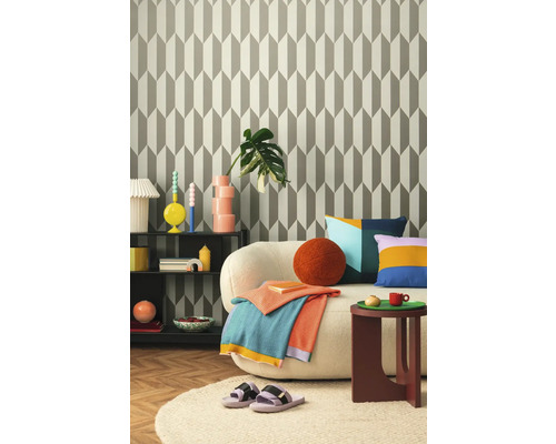 Obývací pokoj s vzorovanou tapetou, pohovkou, odkládacím stolkem a dekoracemi pro útulnou atmosféru.