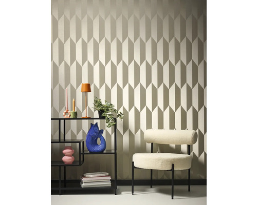 Pohled na pokoj s tapetou se vzorem, regálem a křeslem