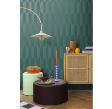 Interiér s dekorativní stěnou, lampou, komodou a dekorativními prvky pro stylové prostředí.