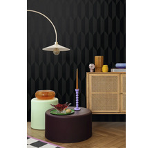 Nábytek v pokoji s tapetou s geometrickým vzorem, stojací lampou a dřevěnou skříňkou