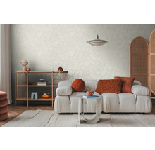 Světlý obývací pokoj s vzorovanou tapetou, pohovkou, kobercem a dřevěnou policí