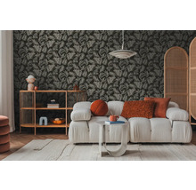 Obývací pokoj s pohovkou, odkládacím stolkem a policí před tapetou se vzorem listů