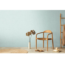 Světlá místnost s dřevěnou židlí, žebříkem, kobercem a dekorací