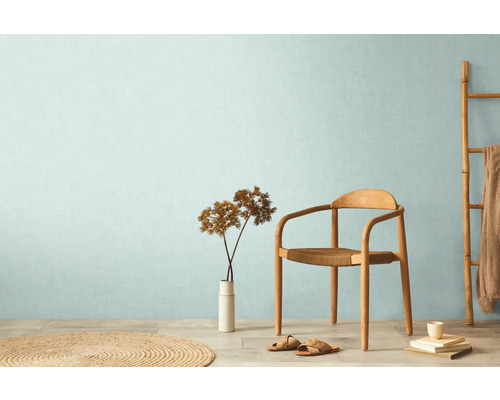 Světlá místnost s dřevěnou židlí, žebříkem, kobercem a dekorací