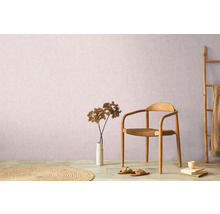 Dekorativní aranžmá obývacího pokoje se židlí, kobercem, dekorací a bambusovým žebříkem před stěnou.