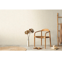 Světlá místnost s dřevěnou židlí, žebříkem a kulatým kobercem