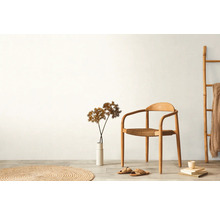 Světlý interiér s dřevěnou židlí, dekorací a textilem