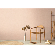 Dekorativní obytné prostředí s dřevěnou židlí, kobercem a pokojovou rostlinou na pozadí decentní zdi