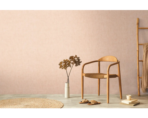 Dekorativní obytné prostředí s dřevěnou židlí, kobercem a pokojovou rostlinou na pozadí decentní zdi